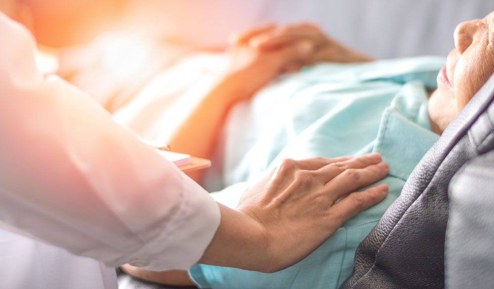 Infirmière mettant sa main sur patient allongé